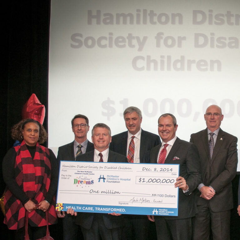 Group of people holding a large check made out to McMaster Children's Hospital Foundation